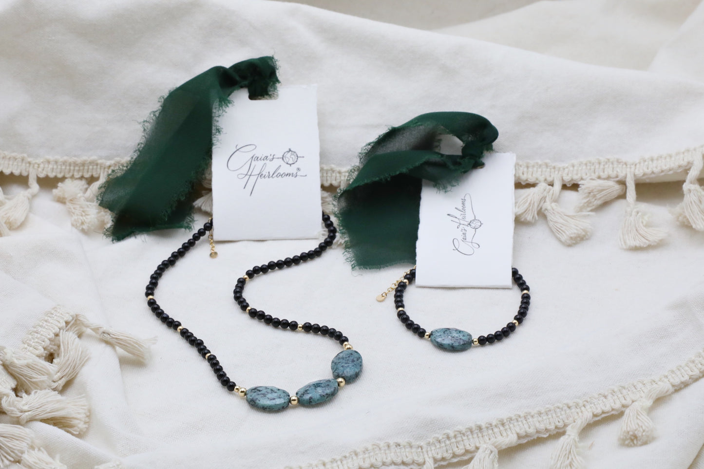 The Fortifying Foundations Necklace and Bracelet by Gaiai's Heirlooms, made with Black Onyx beads, three Blue Spot Jasper stones in the middle and Gold Filled details.