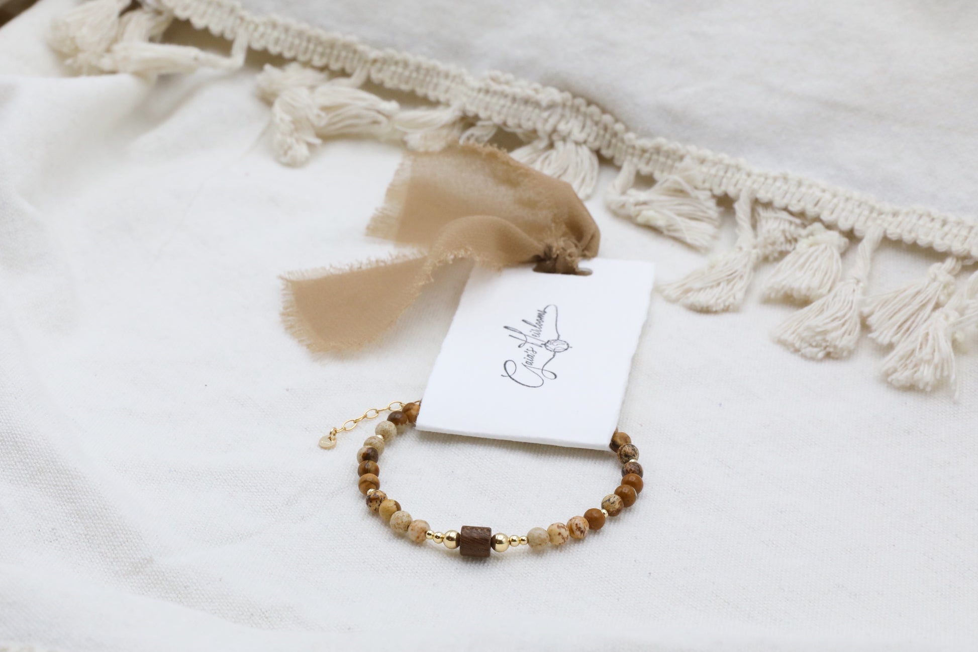 The Earth's Story Bracelet by Gaia's Heirlooms, made with Picture Jasper beads, a natural wood bead in the middle and Gold Filled details.