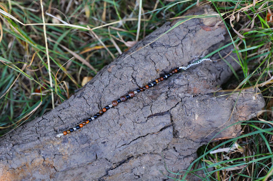 The Fierce Wisdom Bracelet by Gaia's Heirlooms, made with Tiger's Eye, matte Black Onyx, natural wood and oxidised Sterling Silver beads.