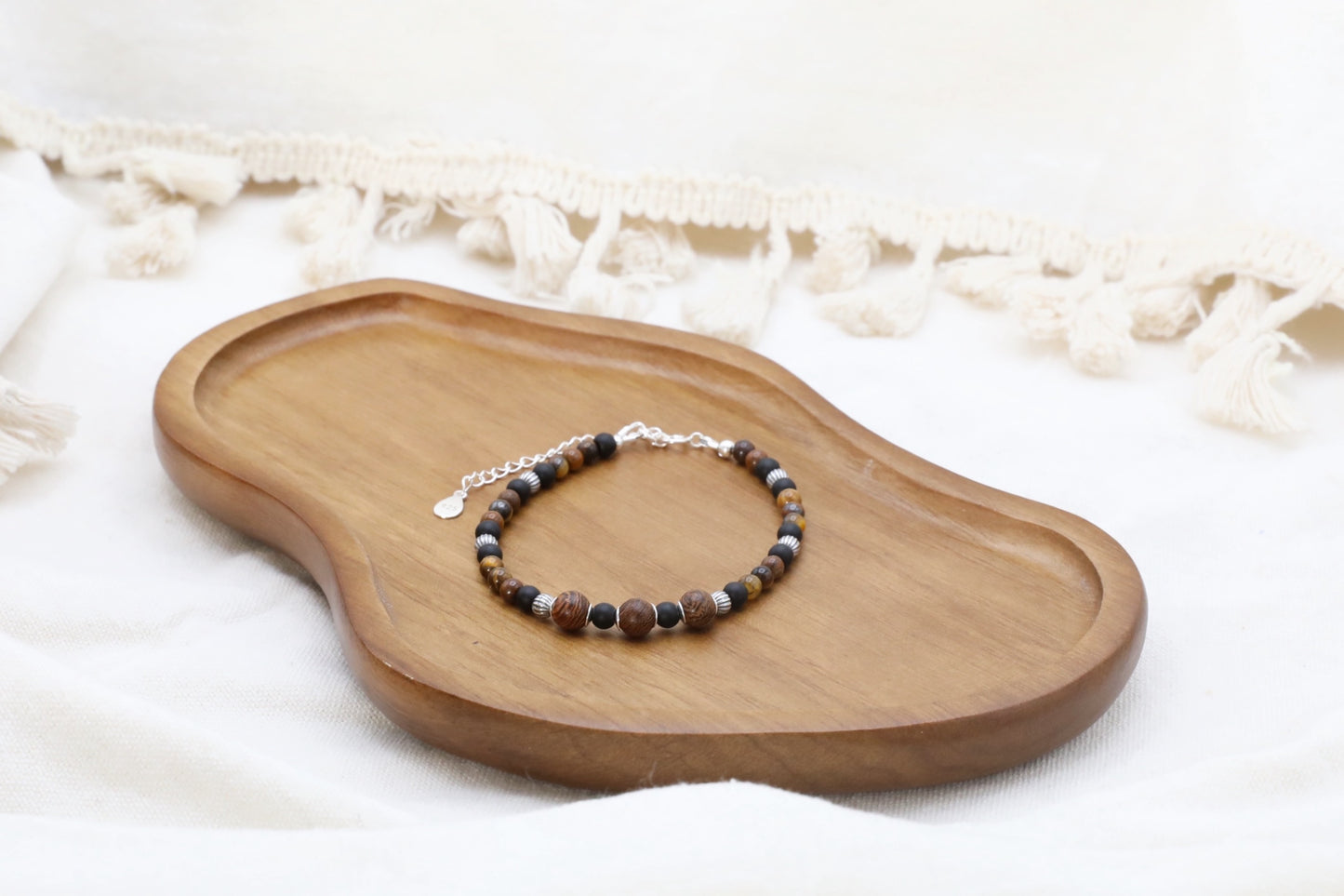 The Fierce Wisdom Bracelet by Gaia's Heirlooms, made with Tiger's Eye, matte Black Onyx, natural wood and oxidised Sterling Silver beads.
