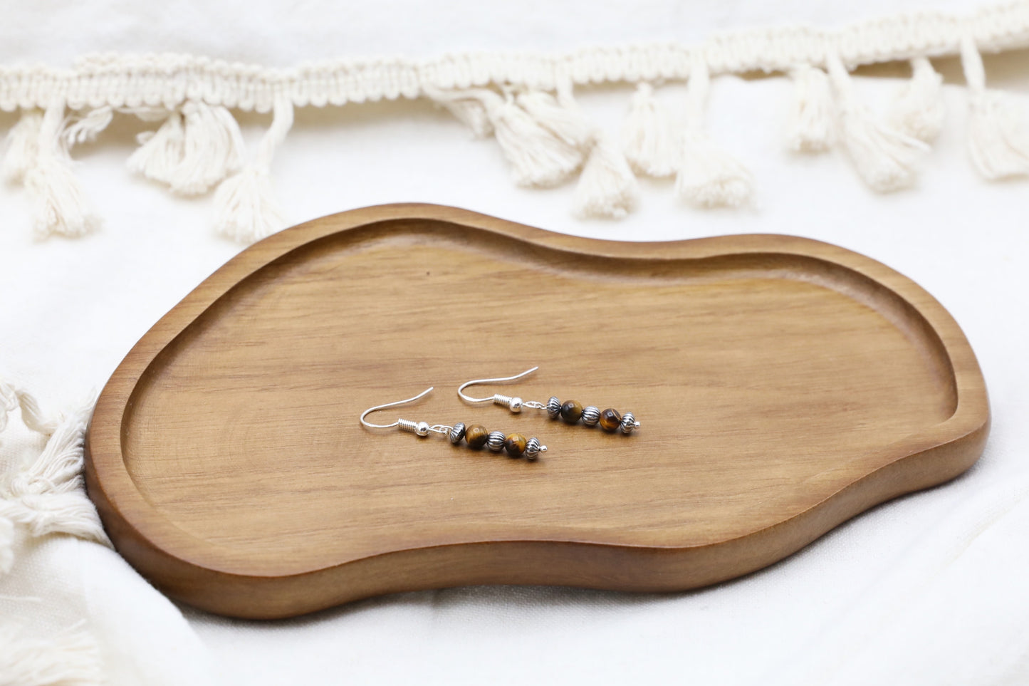 The Fierce Wisdom Earrings from Gaia's Heirlooms, made with Tiger's Eye and oxidised Sterling Silver beads.