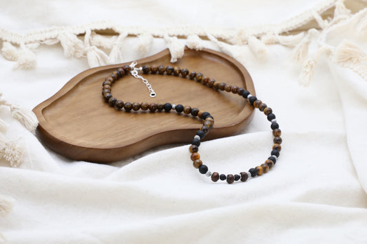 The Fierce Wisdom Necklace by Gaia's Heirlooms, made with Tiger's Eye, matte Black Onyx, natural wood and oxidised Sterling Silver beads.