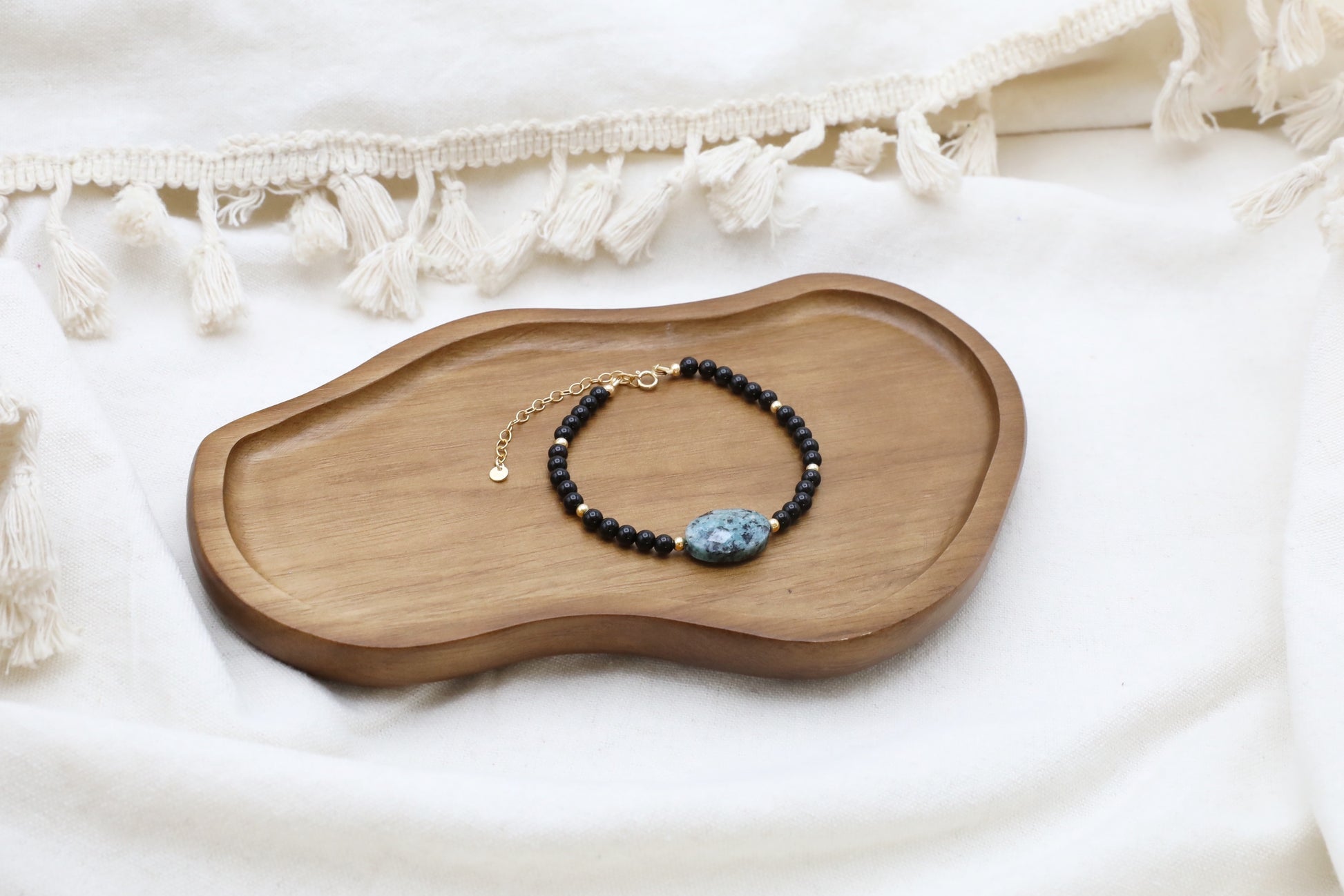 The Fortifying Foundations Bracelet by Gaiai's Heirlooms, made with Black Onyx beads, three Blue Spot Jasper stones in the middle and Gold Filled details.