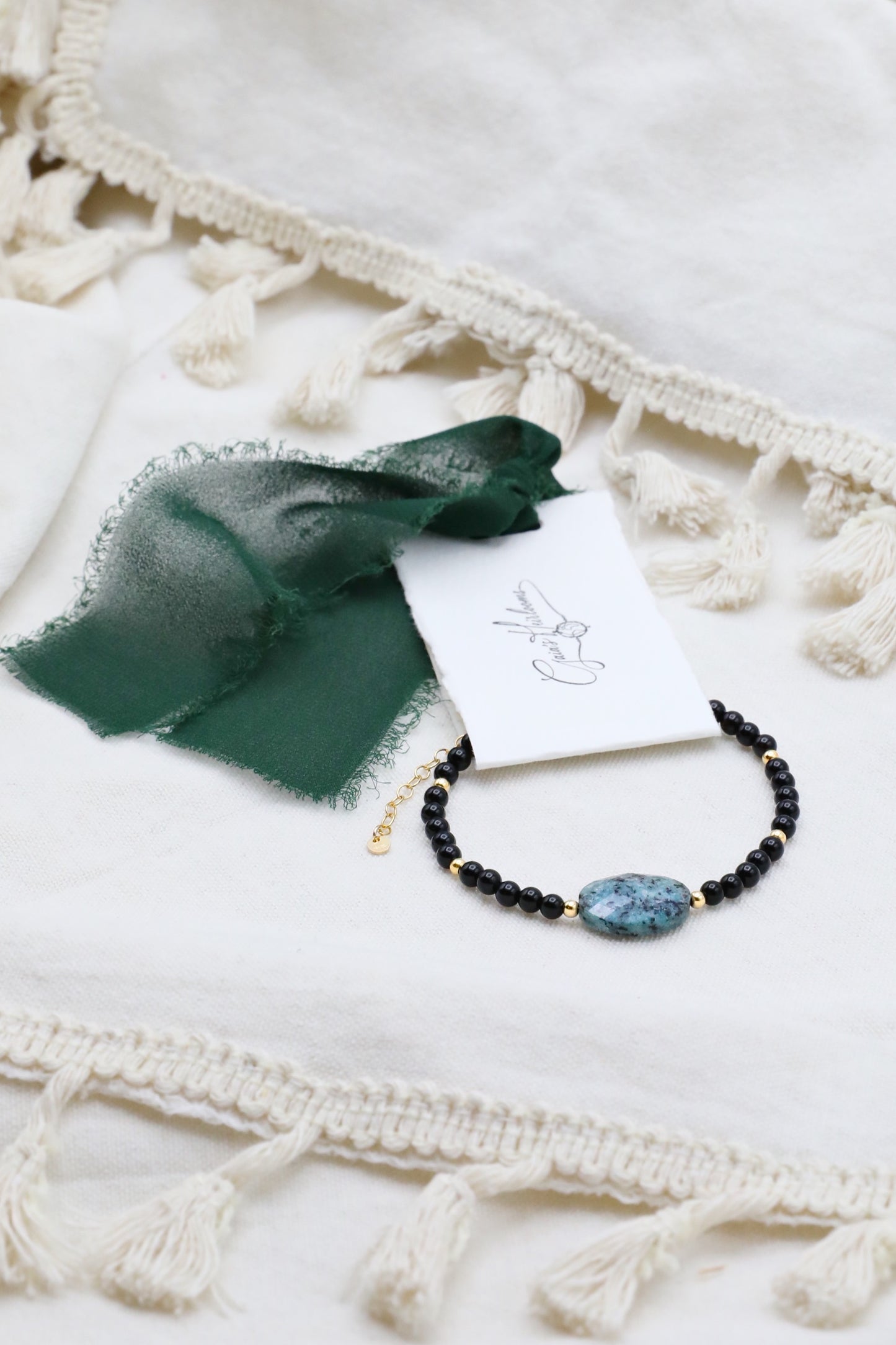 The Fortifying Foundations Bracelet by Gaiai's Heirlooms, made with Black Onyx beads, three Blue Spot Jasper stones in the middle and Gold Filled details.