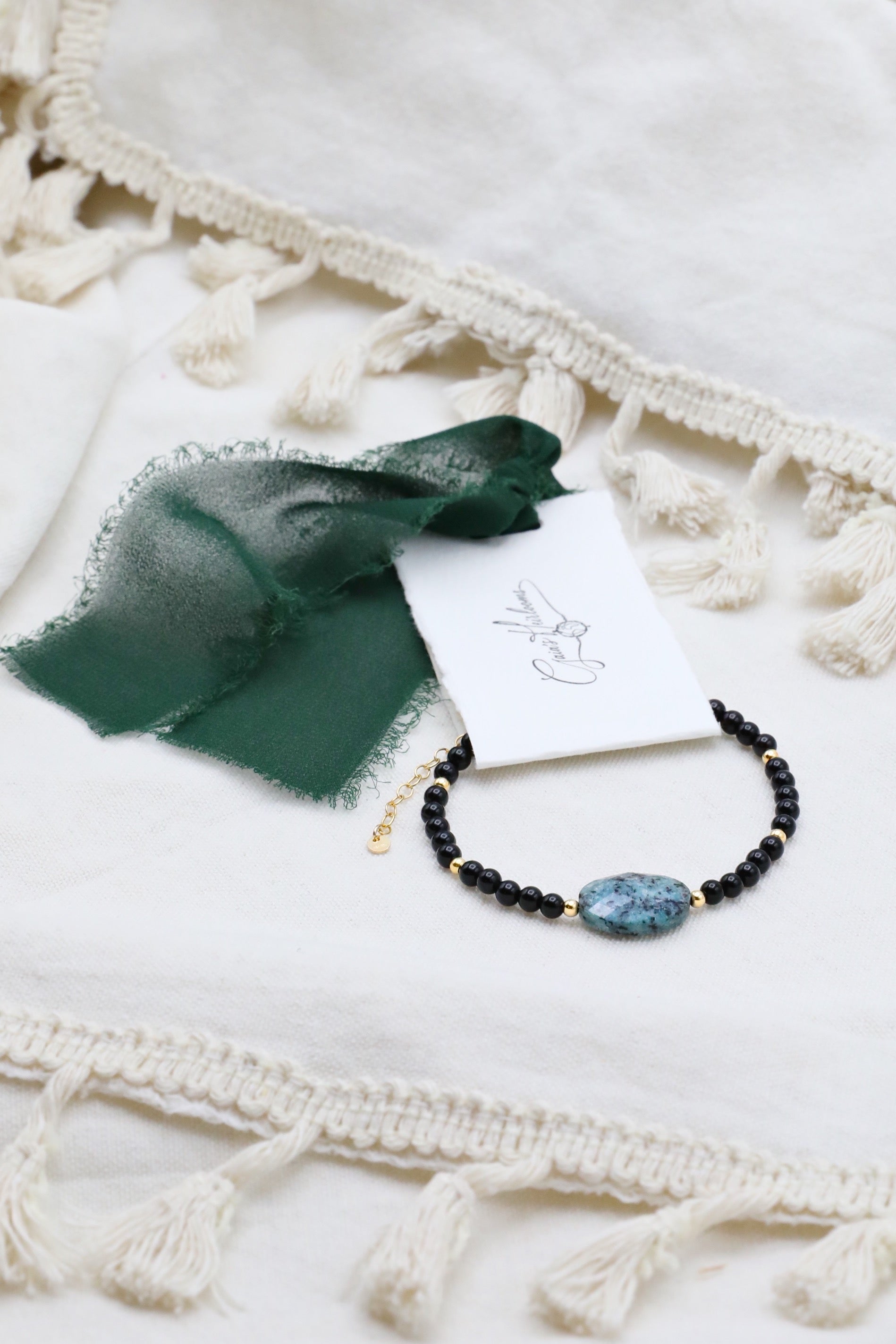 The Fortifying Foundations Bracelet by Gaiai's Heirlooms, made with Black Onyx beads, three Blue Spot Jasper stones in the middle and Gold Filled details.