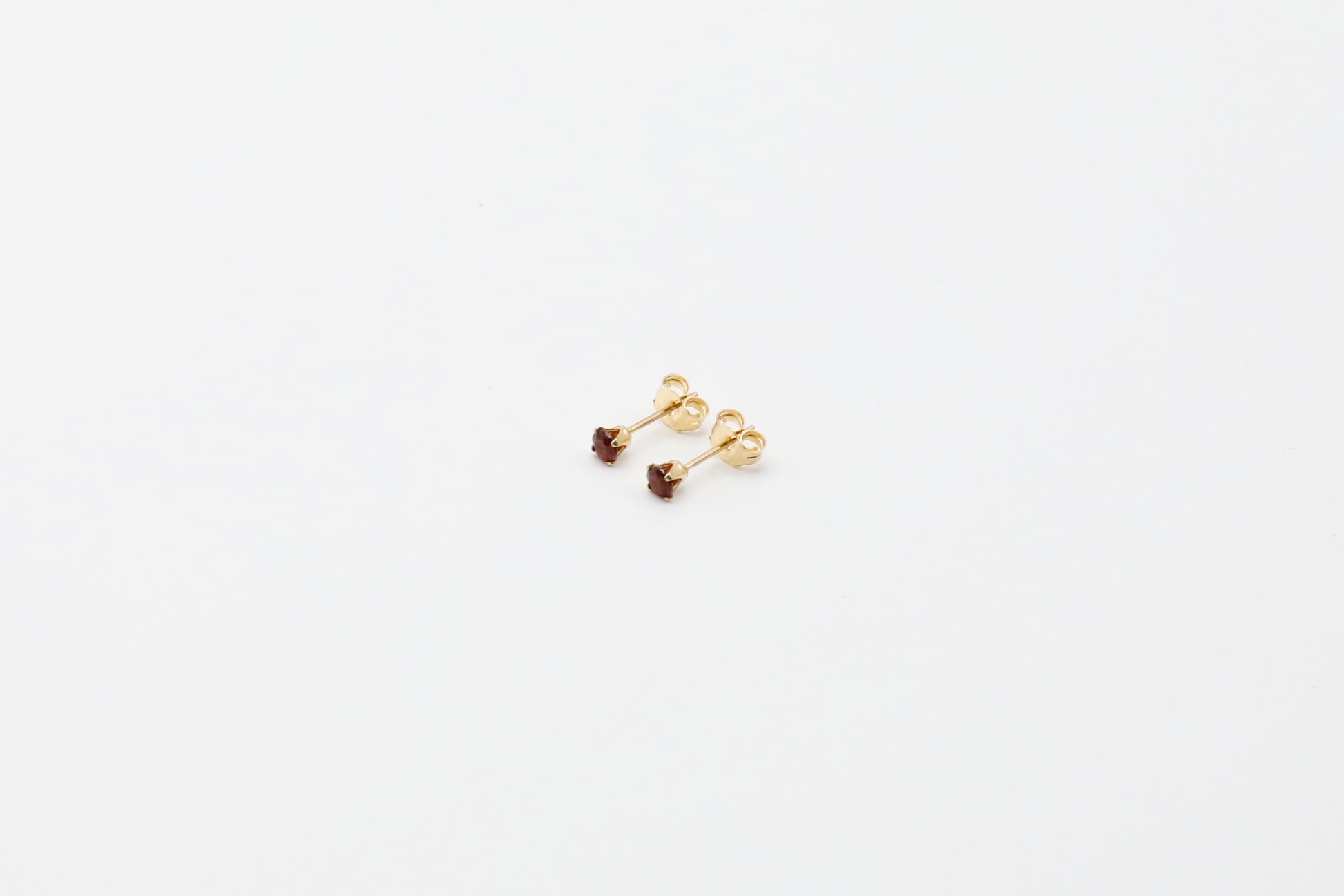 Pair of Garnet stud earrings in Gold Filled. Size: 3mm