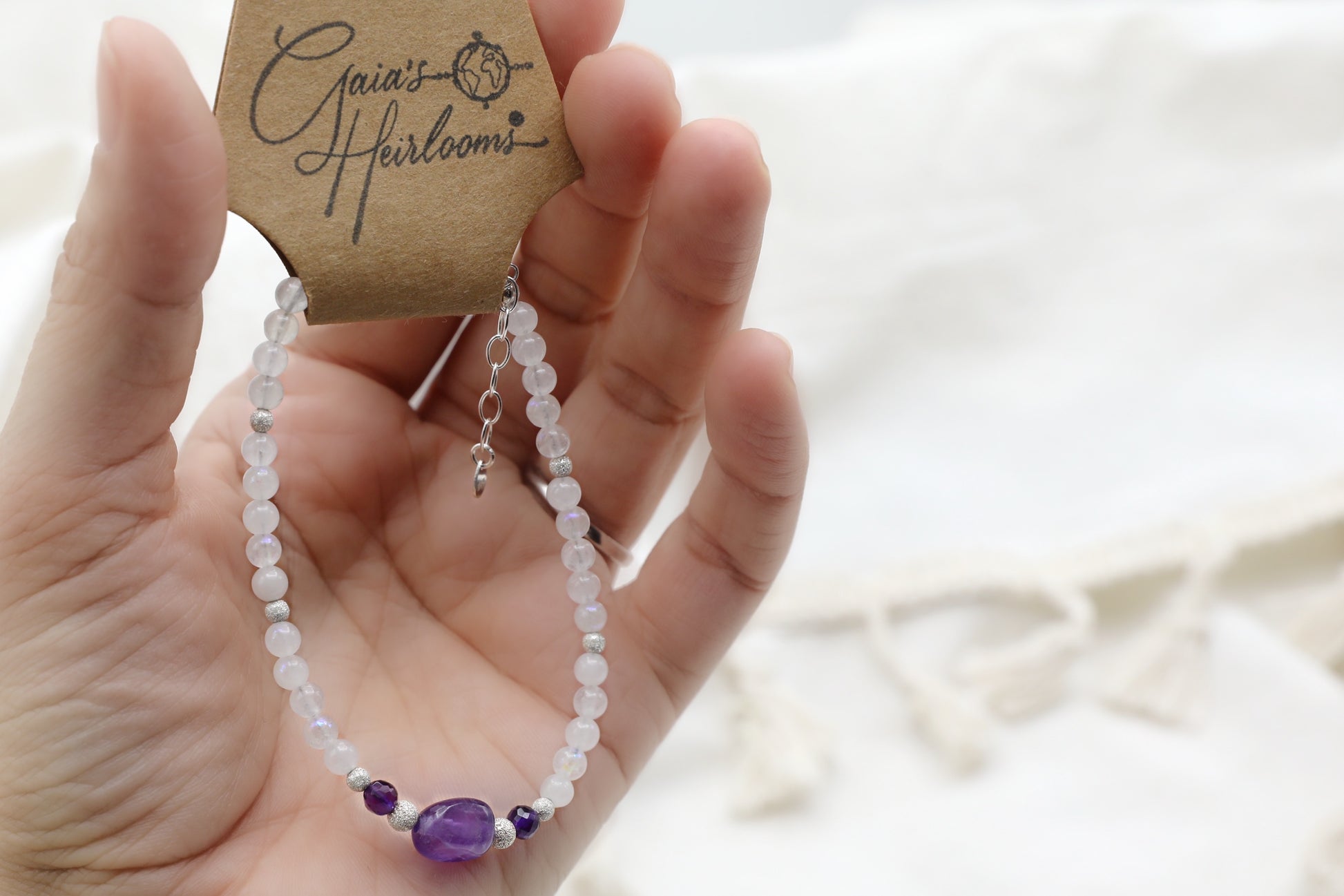 Female hand holding a Moonstone and Amethyst Bracelet with Sterling Silver details