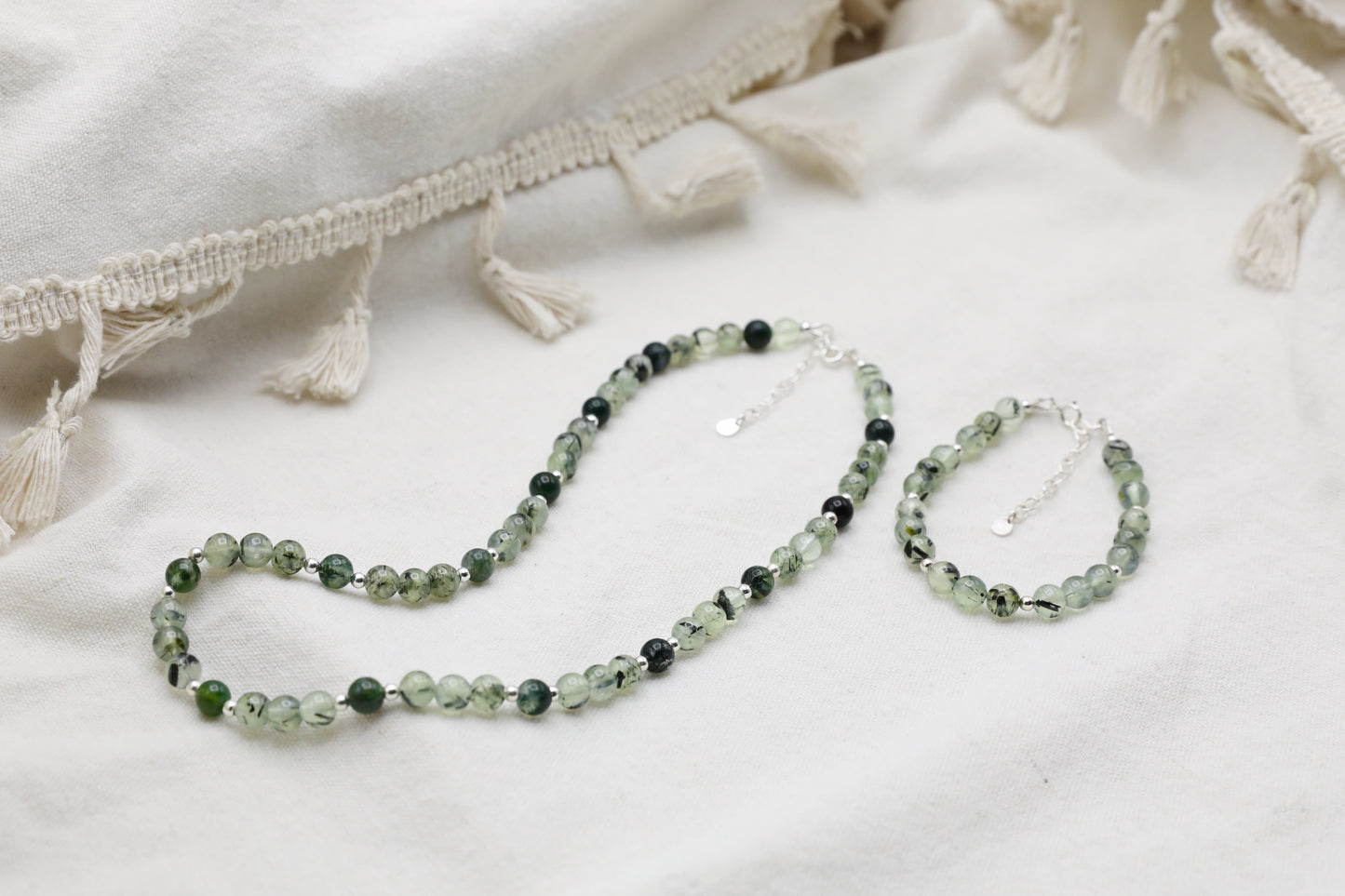 Prehnite Bracelet next to a Prehnite and Moss Agate Necklace, both finished with Sterling Silver details.